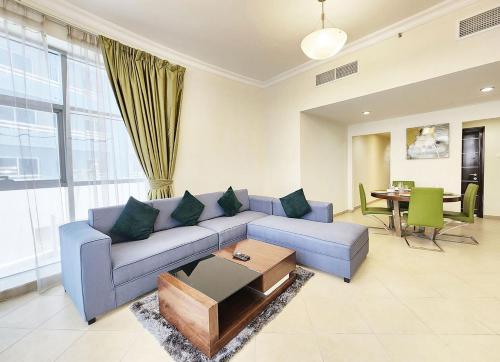 a living room with a blue couch and a table at RH-Prime Location , Spacious 1 Bedroom near Mall of the Emirates in Dubai