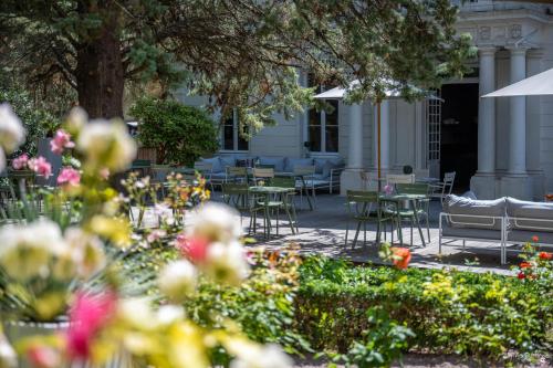 un patio con tavoli, sedie e fiori di Le Champlain a La Rochelle