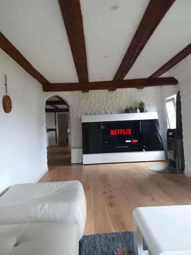 a living room with a white couch and a tv at 3 Bedroom Swiss House on 3 Floors in Oberglatt