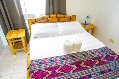Un dormitorio con una cama con dos calcetines. en Baki Divers and Beach Resort, en Dauin