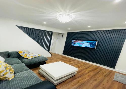 a living room with a couch and a tv at Luxury New Home in Kent