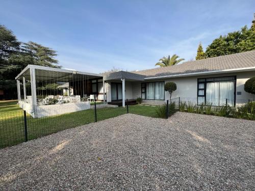 a house with a fence and a gravel driveway at Le'Ciara Luxury Guest House in Johannesburg