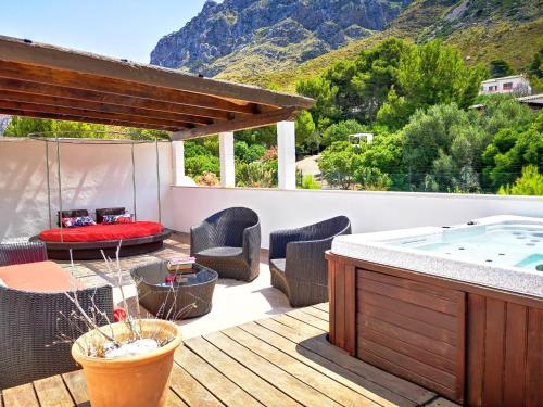 una terraza con bañera de hidromasaje, mesa y sillas en Casa Hokie, en Colonia de San Pedro