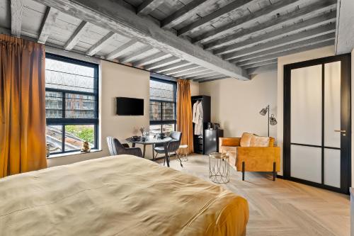 a bedroom with a large bed and a living room at In Den Gouden Beer in Vlissingen
