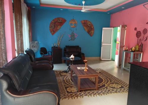 a living room with a couch and a table at Atithya Resort in Khānāpāra