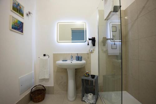 uma casa de banho com um lavatório e uma cabina de duche em vidro. em SALUTAMU em Locogrande