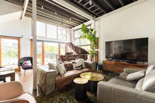 a living room with a couch and a flat screen tv at City View Arthouse in Brisbane