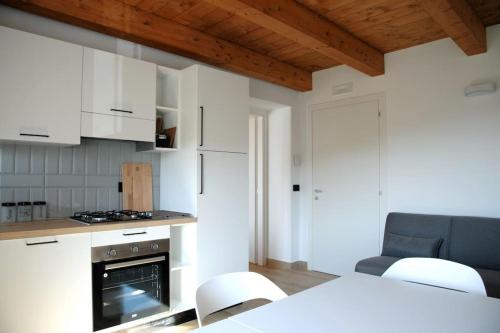 a kitchen with white cabinets and a table and chairs at Tana a 5 STELLE in Capradosso