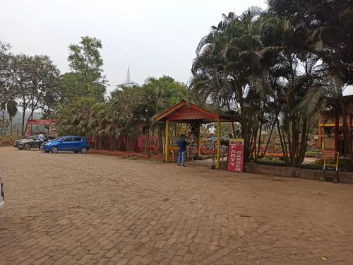 a man standing at a bus stop next to a street at Atithya Resort in Khānāpāra