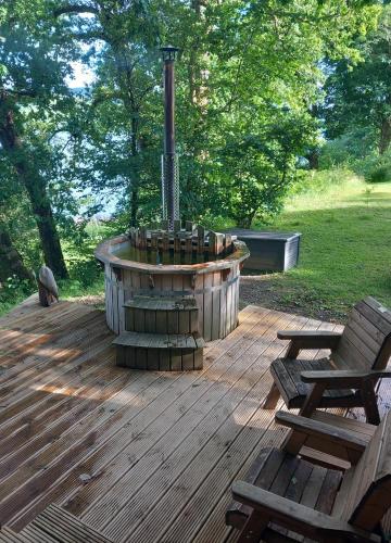 a fire pit on a wooden deck with two benches at Loch Aweside Forest Cabins in Dalavich