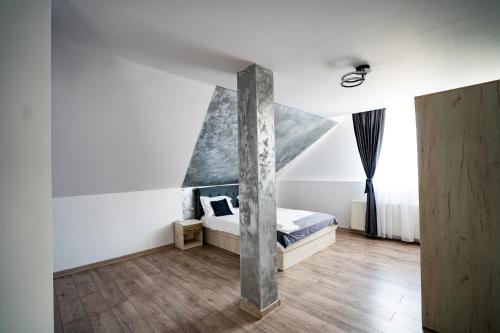 a bedroom with a bed and a large window at Casuta din drumul muntelui in Drăguş