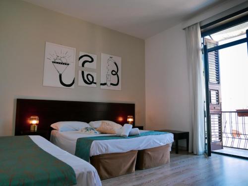 1 dormitorio con 2 camas y ventana en My Friend Antonia, en Barcellona-Pozzo di Gotto