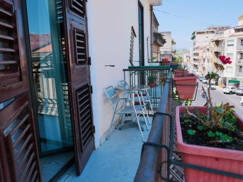 a balcony with a table and chairs on a street at My Friend Antonia in Barcellona-Pozzo di Gotto