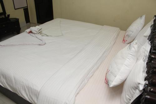 a white bed with white sheets and pillows at AESTHETICS - THE HOME STAY in Shillong