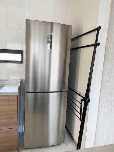 a large stainless steel refrigerator in a kitchen at Rainbow Village（レインボーヴィレッジ） in Mihama