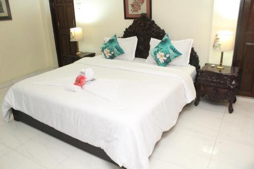 a bedroom with a large white bed with a teddy bear on it at AESTHETICS - THE HOME STAY in Shillong