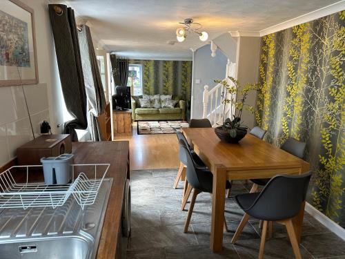 a dining room and living room with a table and chairs at Bay View Cottage in St Austell