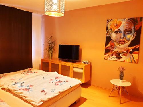 a bedroom with a bed and a painting of a woman at Apartmán Terminál, self check-in 24 h in Banská Bystrica
