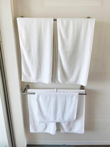 a refrigerator with white towels hanging in it at Rainbow Village（レインボーヴィレッジ） in Mihama