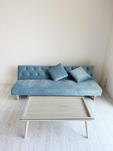 a blue couch in a living room with a coffee table at Rainbow Village（レインボーヴィレッジ） in Mihama
