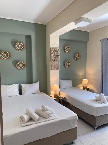 twee bedden in een kamer met handdoeken erop bij kallas apartments in Laganas