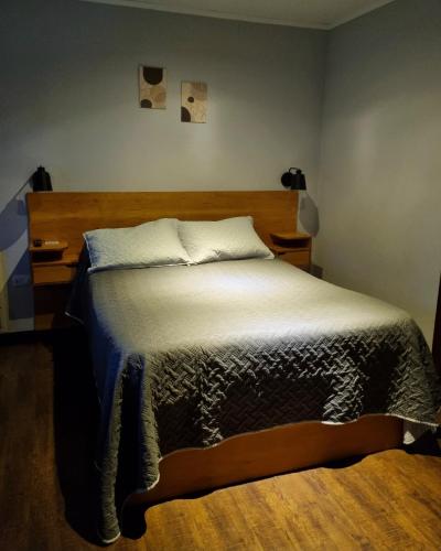 a bedroom with a bed with a wooden headboard at LengaUsh in Ushuaia