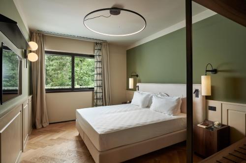 1 dormitorio con cama blanca y ventana en Maximilian Suites, en Trieste