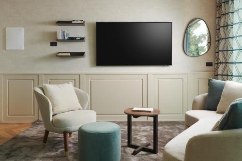 uma sala de estar com uma televisão de ecrã plano na parede em Maximilian Suites em Trieste