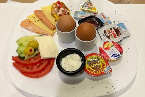 a plate of food with eggs and cheese and vegetables at Hotel LaCorte Prishtina in Pristina