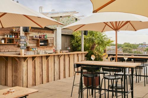a bar with tables and umbrellas on a patio at Kingsland Locke in London