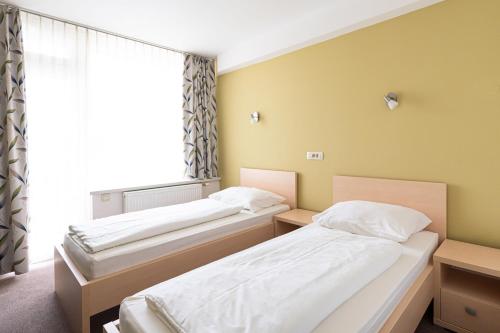 two beds in a room with a window at Grajski Dvor in Radovljica