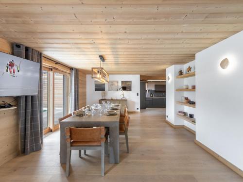 une cuisine et une salle à manger avec une table et des chaises dans l'établissement Appartement neuf, spacieux et lumineux à Megève, proche des remontées mécaniques et du centre - FR-1-569-60, à Megève