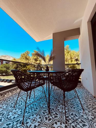 een patio met een tafel en stoelen op een balkon bij Apartment Talija in Trebinje
