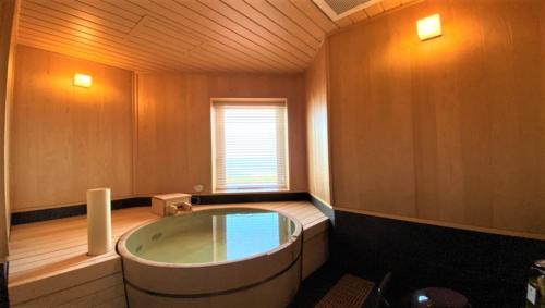 a bathroom with a large tub in a room with a window at La vista Kannonzaki Terrace in Yokosuka
