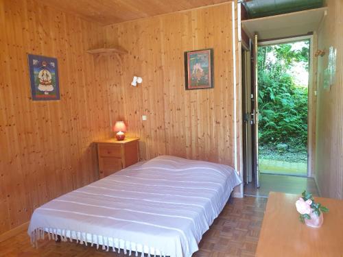 a bedroom with a bed in a room with wooden walls at Domaine d'Avallon - petit Tibet au coeur des Alpes in Arvillard