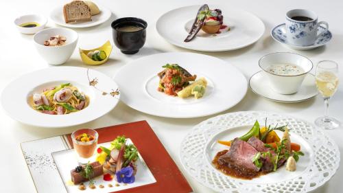 stół z białymi talerzami żywności w obiekcie La vista Kannonzaki Terrace w mieście Yokosuka