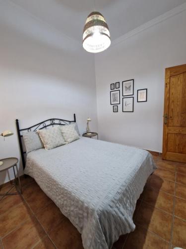 een witte slaapkamer met een bed en een lamp bij Kgemelas in Telde