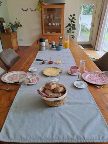 a table with a table cloth with a basket of food at Garden studio in Rijsbergen