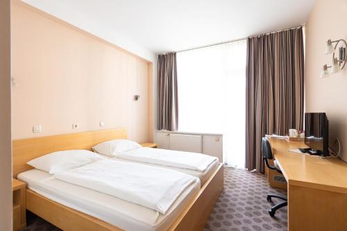 a hotel room with a bed and a desk and a computer at Grajski Dvor in Radovljica