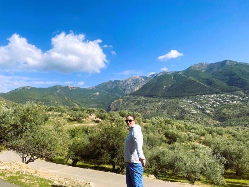 a man standing on a hill with mountains in the background at Harmony Home in Alcaucín