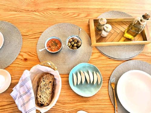 a wooden table topped with plates and bowls of food at Harmony Home in Alcaucín