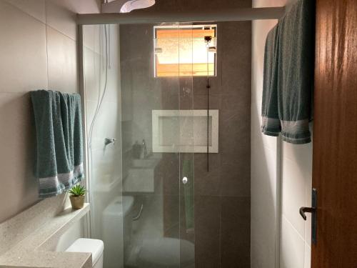 uma casa de banho com um chuveiro, um WC e um lavatório. em Pousada Chalé Flor de Hibisco 1 em Penha