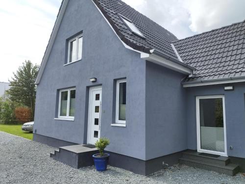 a gray house with a potted plant in front of it at Ferienhaus in Handewitt kurz vor dänischen Grenze in Handewitt