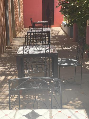 a group of chairs sitting on a sidewalk at Riad Bouchra in Tamtetoucht