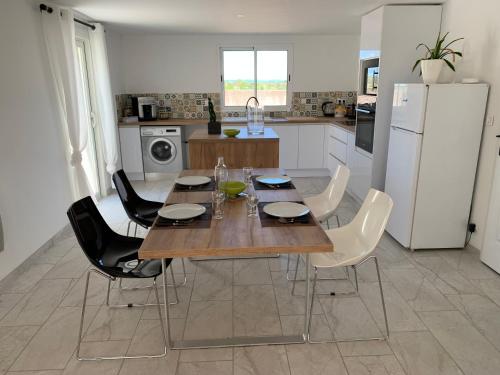 une cuisine avec une table en bois et des appareils électroménagers blancs dans l'établissement Location saisonnière, à Béziers