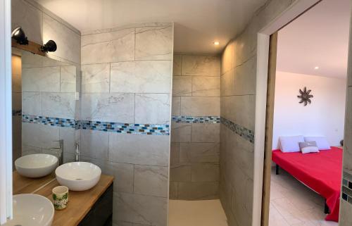 une salle de bain avec deux lavabos et une douche dans l'établissement Location saisonnière, à Béziers