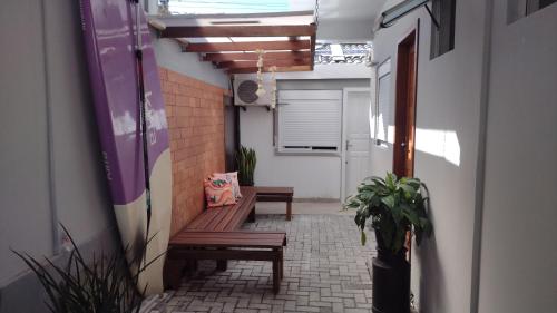un pasillo con bancos y plantas en un edificio en Rosa dos ventos suíte 1, en Florianópolis