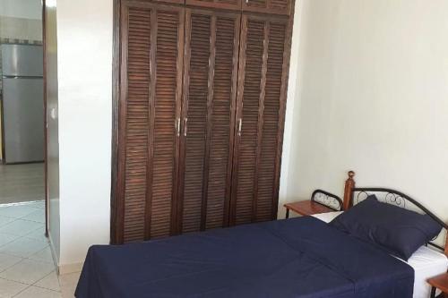 ein Schlafzimmer mit einem blauen Bett und einem Holzschrank in der Unterkunft Le jaune d'Ifni in Agadir