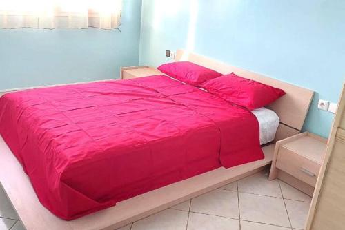 ein Bett mit einer roten Bettdecke in einem Schlafzimmer in der Unterkunft Le jaune d'Ifni in Agadir