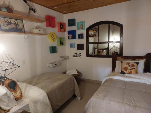 1 dormitorio con 2 camas y espejo en Casas Bueno en Camanducaia